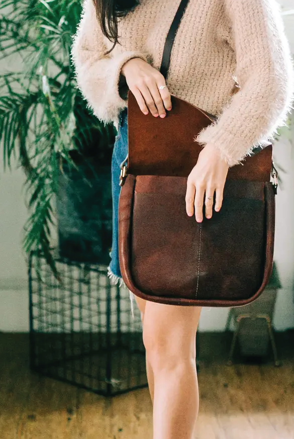 Brown leather bag hung on someone's shoulder